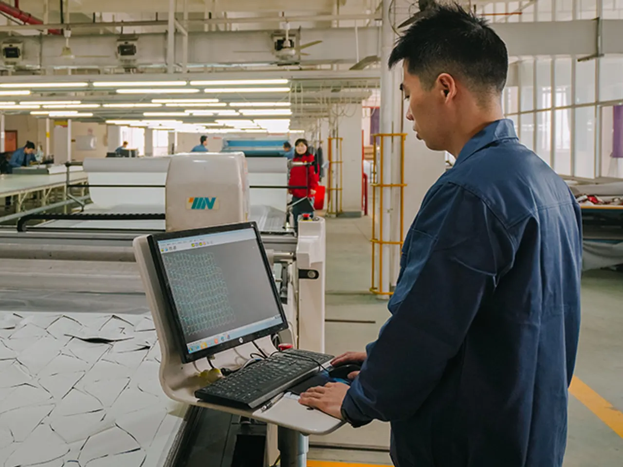 Operator at a CNC fabric cutting machine in the Baizhijia workshop